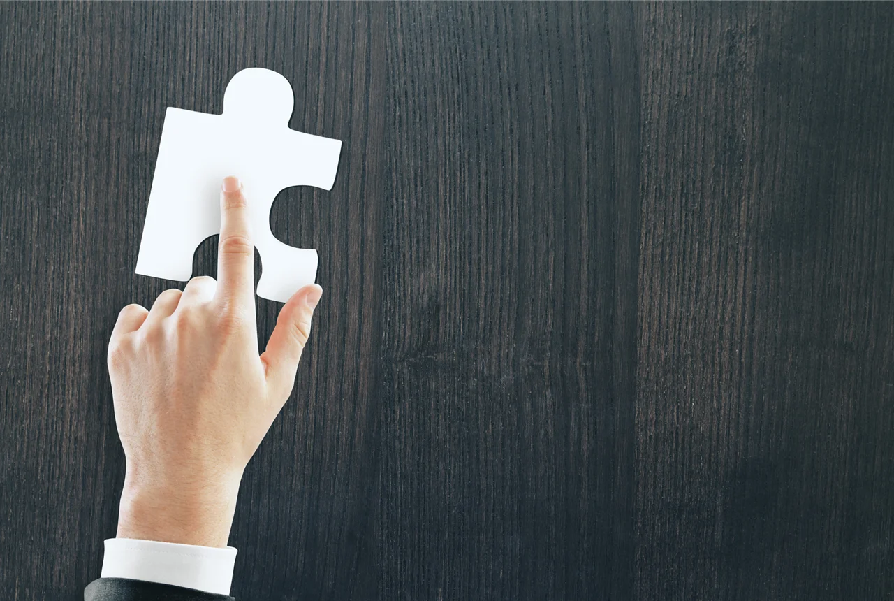 Mão a colocar a última peça de um puzzle, simbolizando o SEO como a peça que faltava para transformar um site numa ferramenta de vendas para PME.